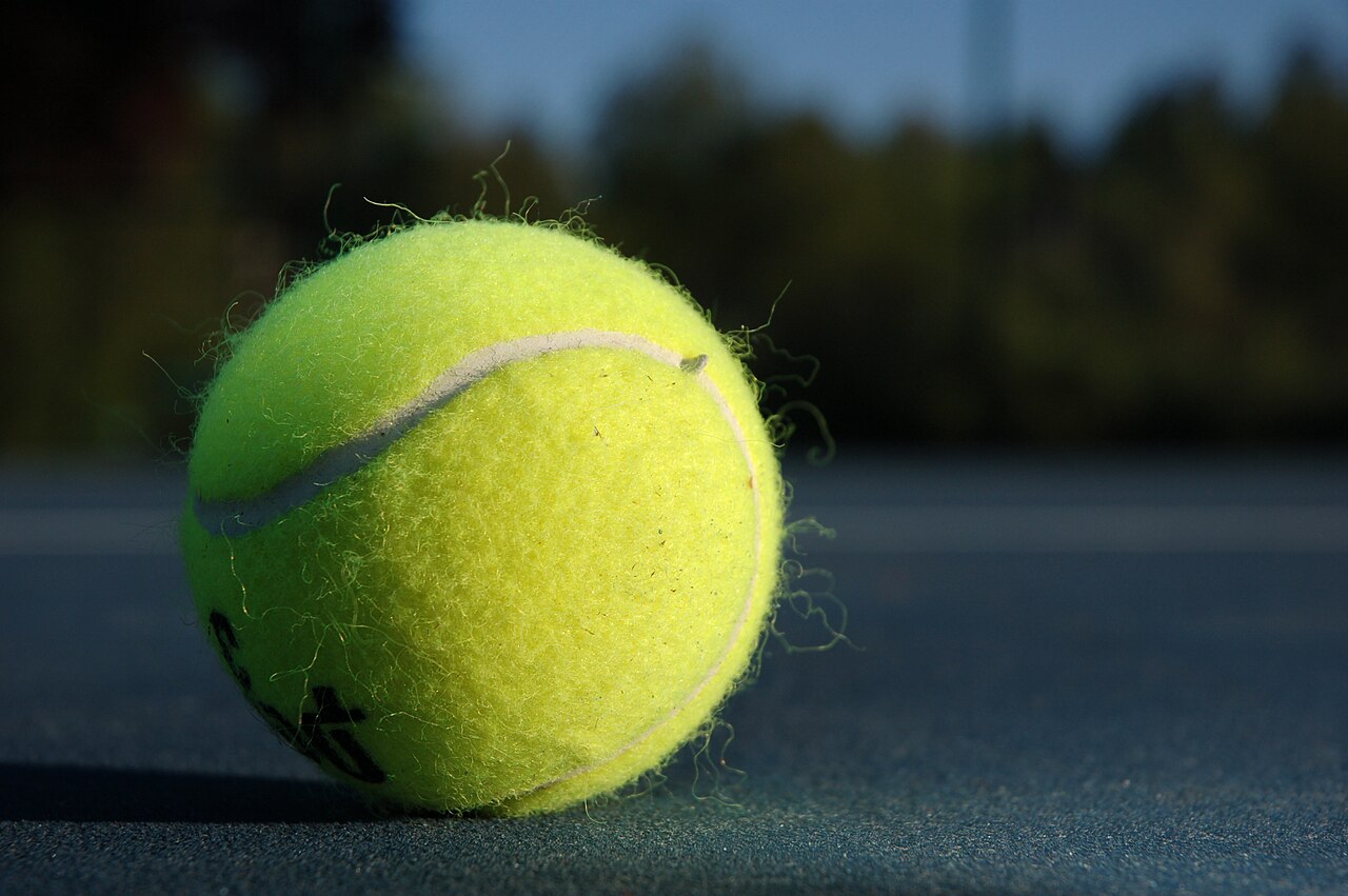 Close-up of a tennis ball on a hard court