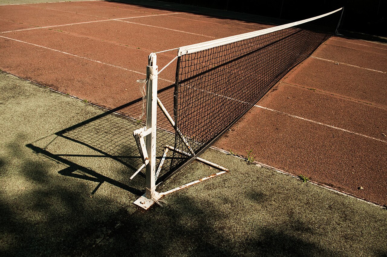 A tennis net stretched across an outdoor court