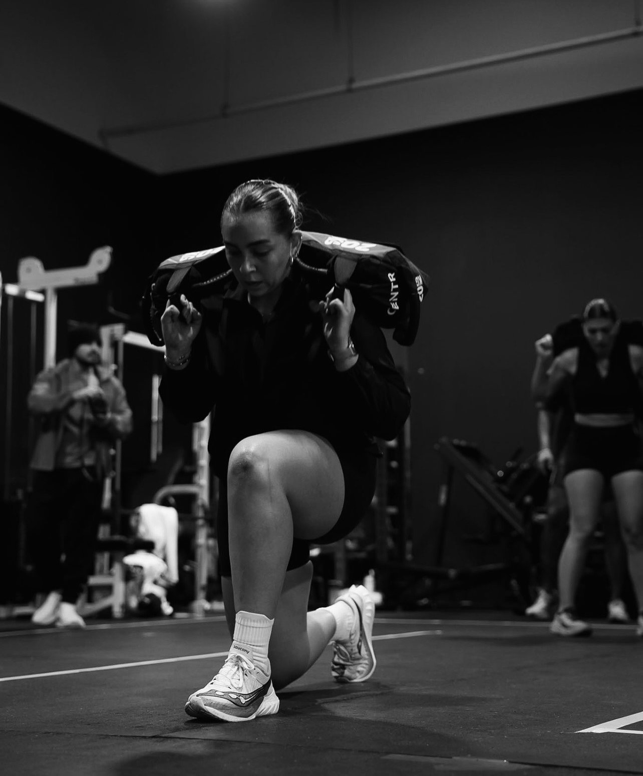 Athlete doing sandbag lunges during a Raw Performance class